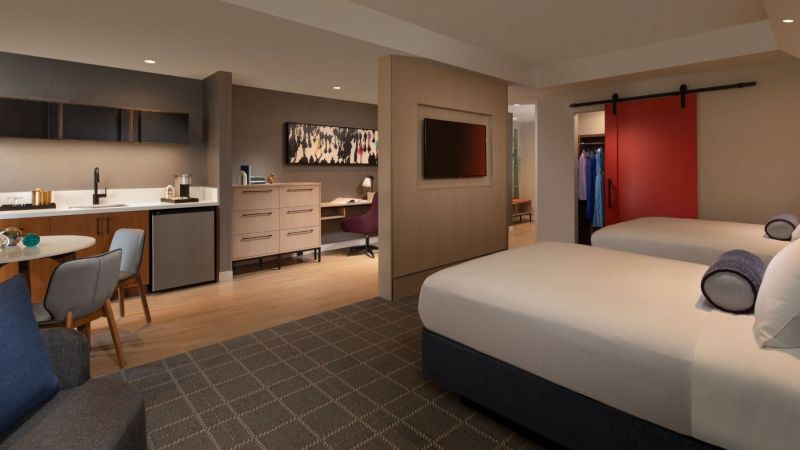 Two Queen Junior Suite sleeping area with a view of the kitchenette 