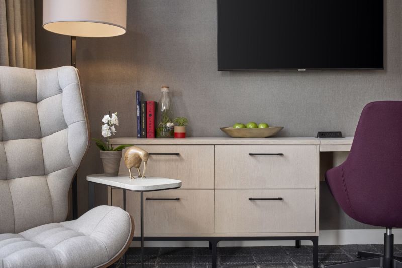 Desk area with television on the wall and sitting chair in the window