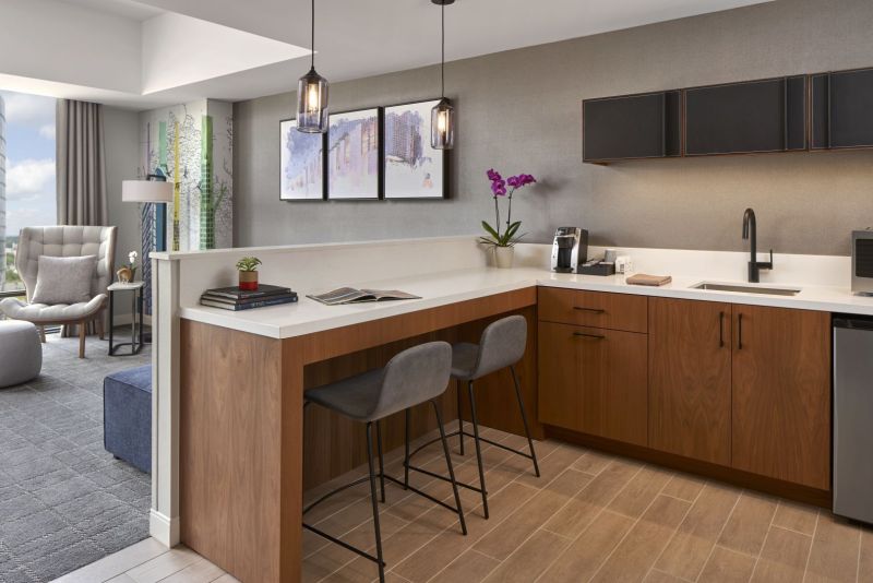 Kitchenette area with bar top and barstools  overlooking the living area of the suite