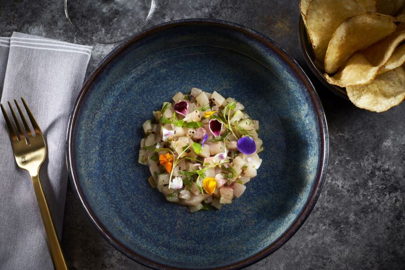 Food in a blue bowl with gold fork