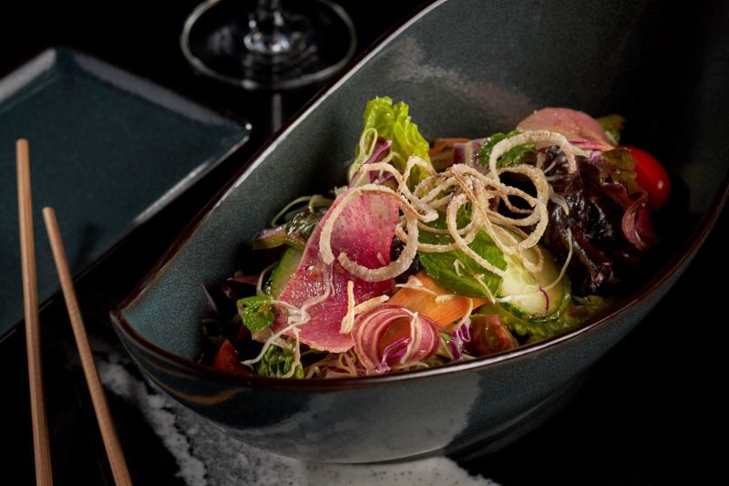 Food in a blue bowl with chopsticks