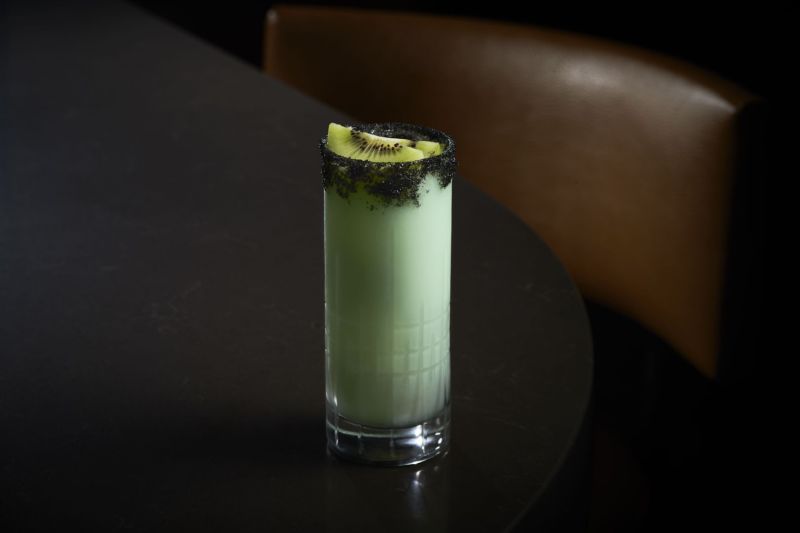 Green cocktail in a rocks glass with kiwi garnish