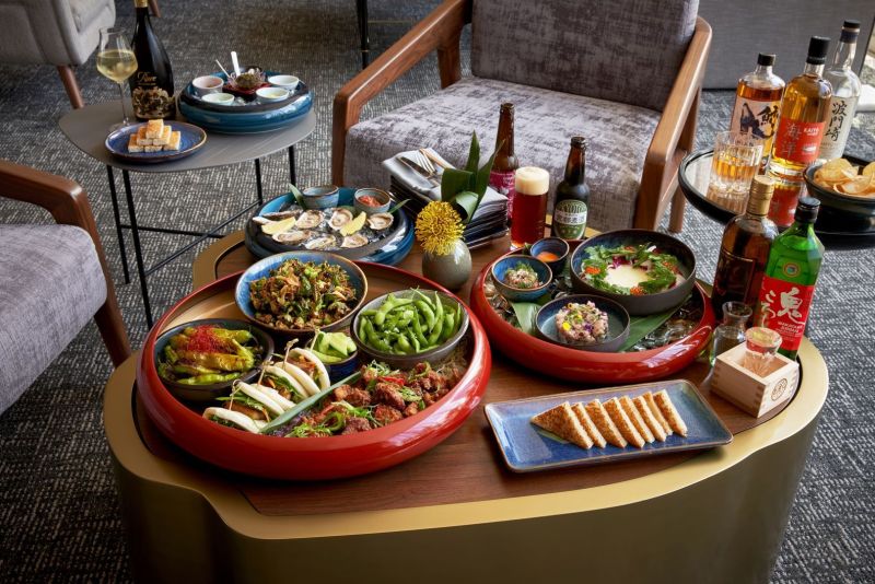 Food spread setup on a coffee table in a room with a few bottles of alcohol