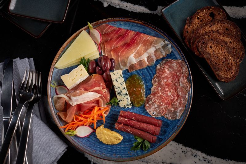 Meat and cheese spread on a round blue plate